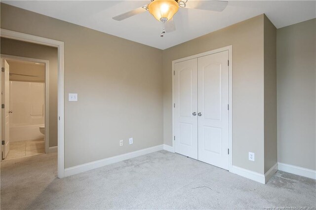 unfurnished bedroom with light colored carpet, ceiling fan, and a closet