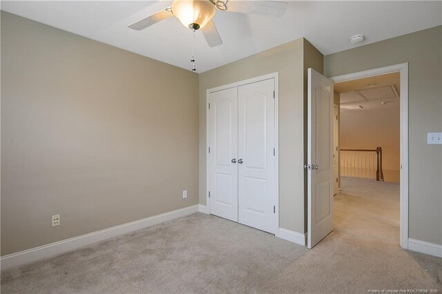 unfurnished bedroom with light carpet, a closet, and ceiling fan