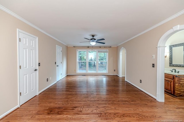 unfurnished living room with ceiling fan, hardwood / wood-style flooring, crown molding, and sink