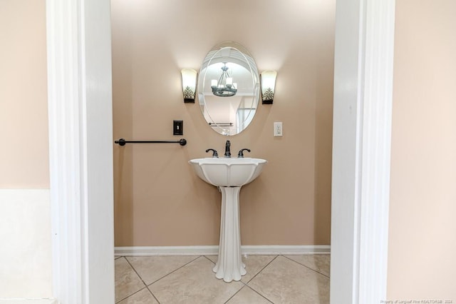 bathroom featuring tile patterned flooring and a chandelier