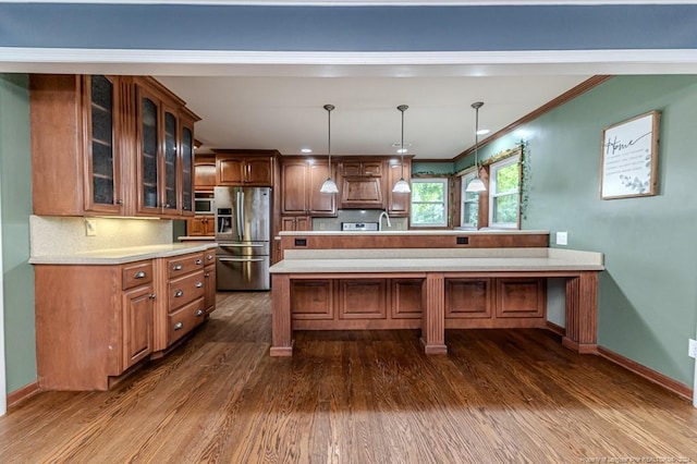 kitchen with dark hardwood / wood-style flooring, pendant lighting, crown molding, a large island, and stainless steel refrigerator with ice dispenser