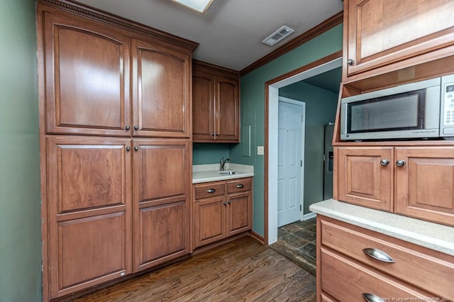 kitchen featuring sink, dark hardwood / wood-style floors, and ornamental molding