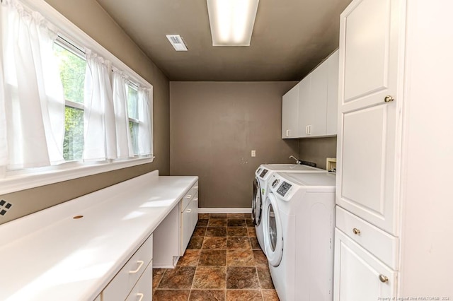 washroom featuring cabinets and washing machine and dryer