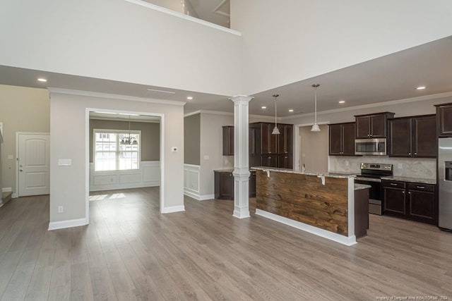 5737 Pooh Ave, Stedman, NC 28391 - kitchen with stainless steel appliances, dark brown cabinetry, light wood finished floors, ornate columns, and crown molding