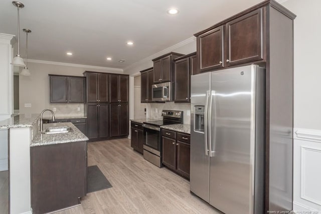 5737 Pooh Ave, Stedman, NC 28391 - kitchen featuring appliances with stainless steel finishes, a sink, dark brown cabinets, light wood-type flooring, and light stone counters