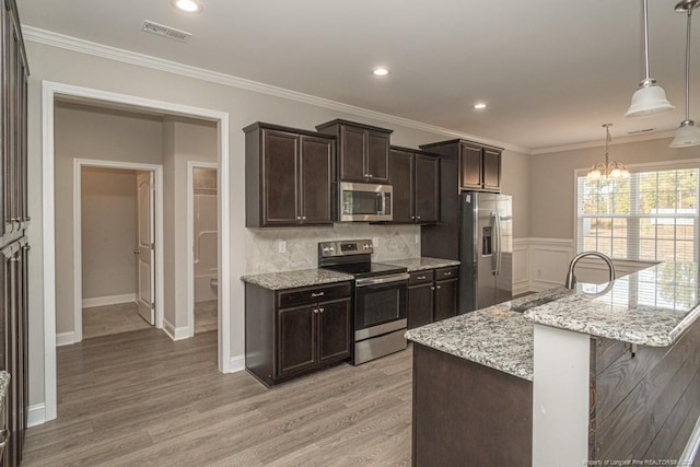 5737 Pooh Ave, Stedman, NC 28391 - kitchen with stainless steel appliances, a chandelier, dark brown cabinetry, light wood-style flooring, and ornamental molding