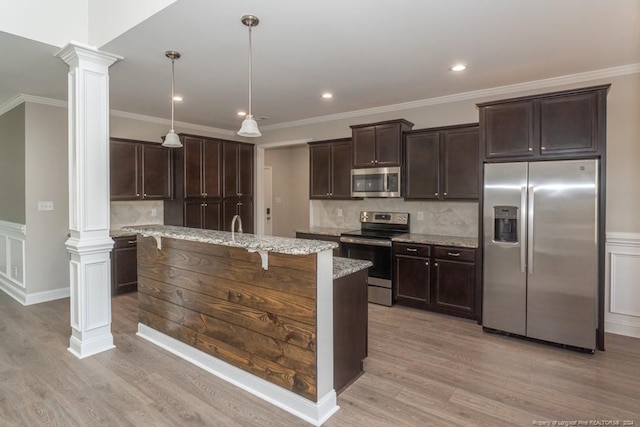 5737 Pooh Ave, Stedman, NC 28391 - kitchen with stainless steel appliances, ornate columns, dark brown cabinetry, light wood-type flooring, and crown molding