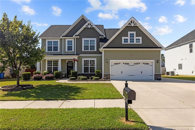 craftsman inspired home with a garage, a front lawn, and central AC unit