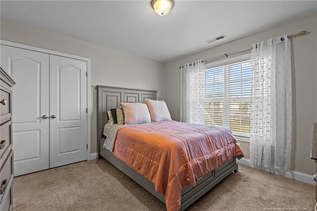 bedroom featuring light carpet and a closet