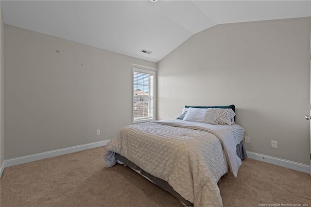 bedroom with light colored carpet and vaulted ceiling