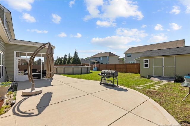 view of patio featuring a swimming pool, a shed, and area for grilling