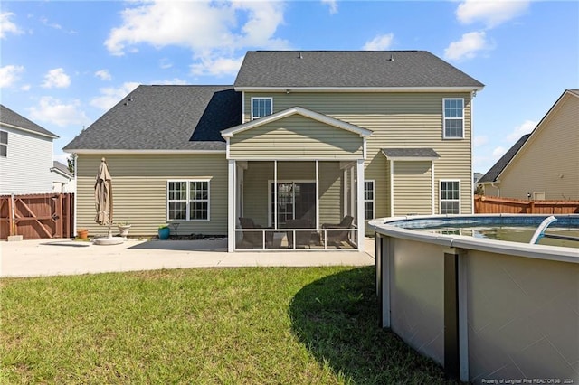 rear view of property featuring a yard and a sunroom