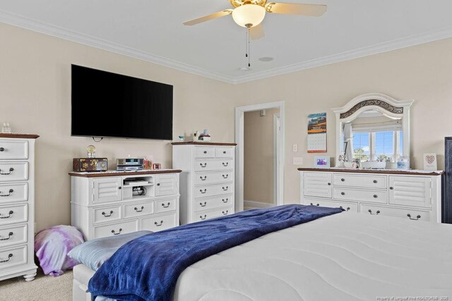 carpeted bedroom featuring ceiling fan and crown molding