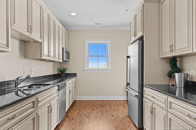 kitchen featuring cream cabinets, light hardwood / wood-style flooring, stainless steel appliances, crown molding, and sink