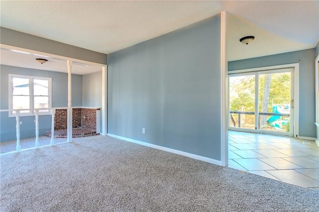 tiled spare room with a textured ceiling and plenty of natural light