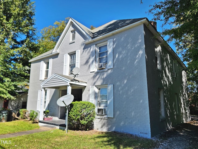 view of front of home featuring cooling unit and a front lawn