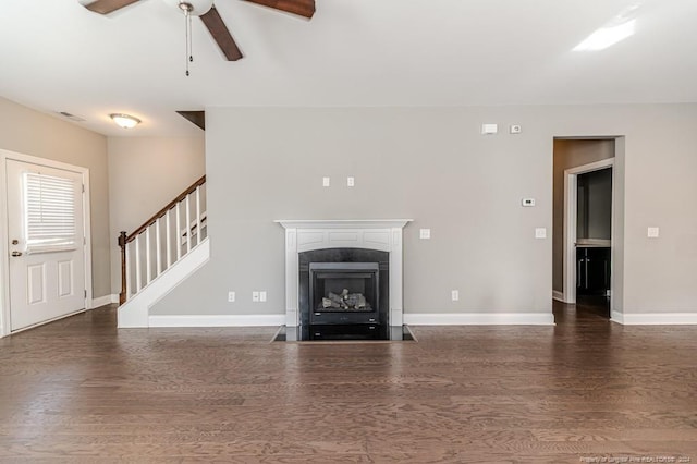 unfurnished living room with ceiling fan and dark hardwood / wood-style flooring