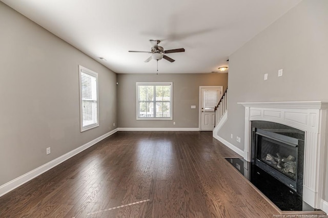 unfurnished living room with ceiling fan and dark wood-type flooring