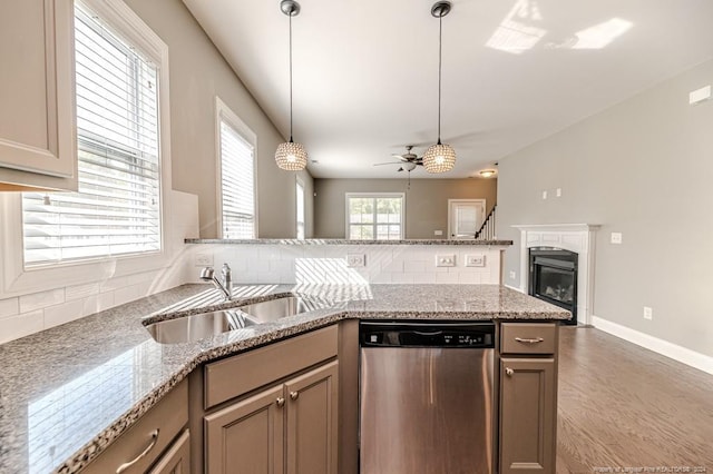 kitchen featuring tasteful backsplash, wood-type flooring, sink, dishwasher, and hanging light fixtures