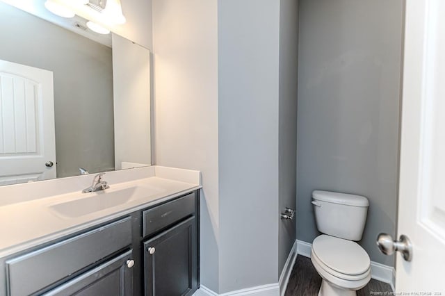 bathroom featuring wood-type flooring, vanity, and toilet