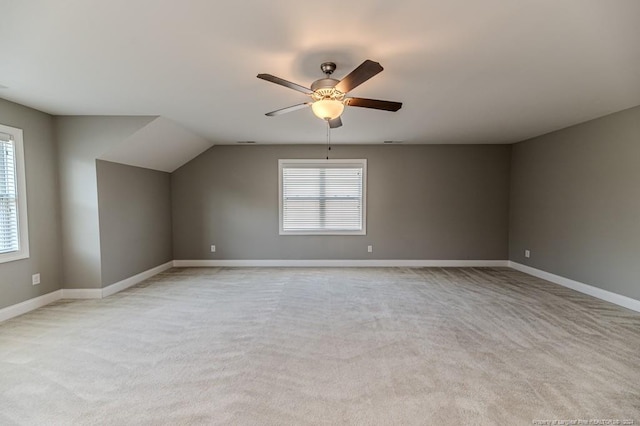 additional living space featuring ceiling fan, vaulted ceiling, and light colored carpet