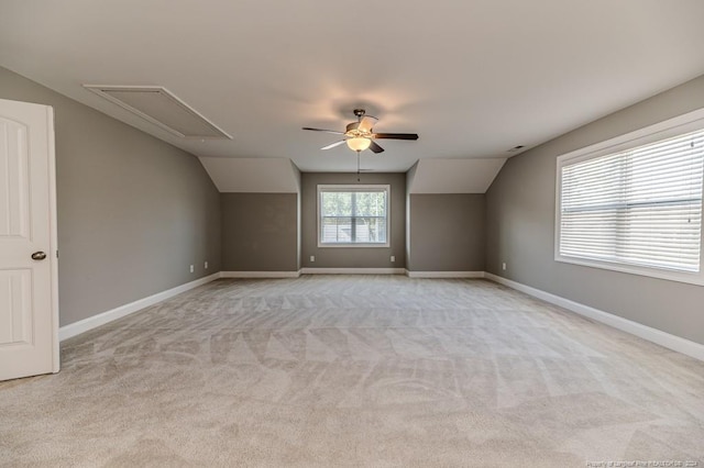 additional living space with ceiling fan, vaulted ceiling, and light colored carpet