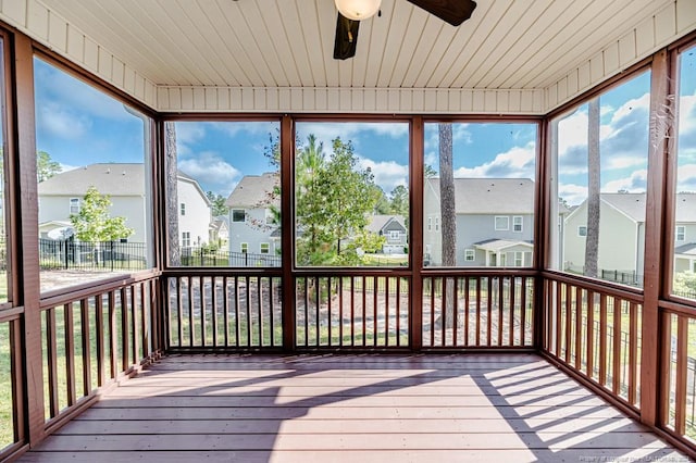 unfurnished sunroom featuring ceiling fan, plenty of natural light, and wood ceiling