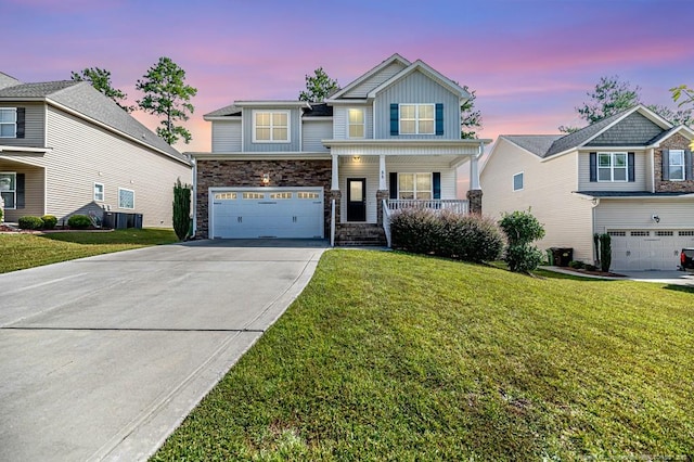 view of front of home with a garage, a porch, and a lawn