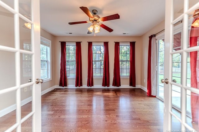 empty room featuring hardwood / wood-style floors, ceiling fan, and french doors