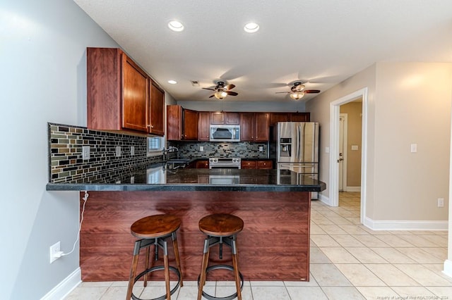 3375 Carolina Way, Sanford, NC 27332 - kitchen with appliances with stainless steel finishes, a peninsula, tasteful backsplash, ceiling fan, and light tile patterned floors