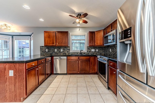 kitchen with ceiling fan, light tile patterned floors, sink, appliances with stainless steel finishes, and decorative backsplash