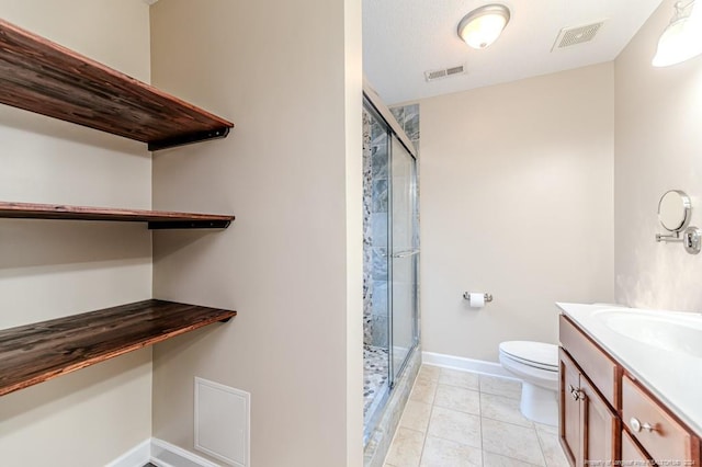 bathroom featuring vanity, toilet, a shower with door, and tile patterned floors