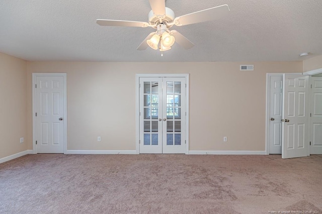 empty room with french doors, light colored carpet, a textured ceiling, and ceiling fan