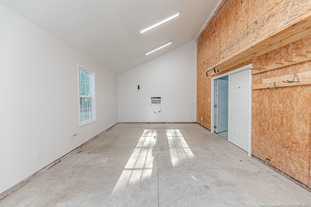 spare room featuring concrete flooring and lofted ceiling