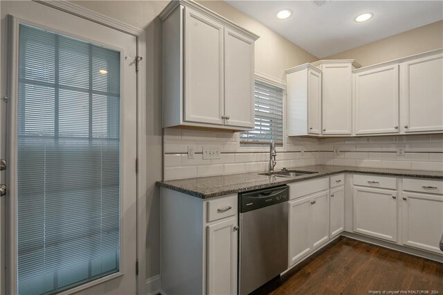 kitchen featuring white cabinets, sink, dark wood-type flooring, dishwasher, and dark stone countertops