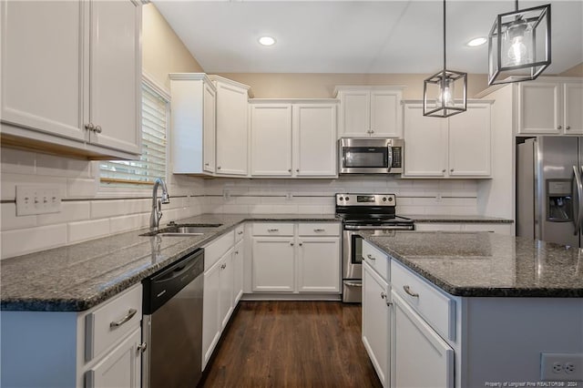 kitchen featuring appliances with stainless steel finishes, pendant lighting, sink, and white cabinets