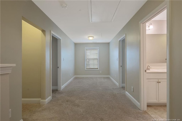 corridor with light carpet and sink