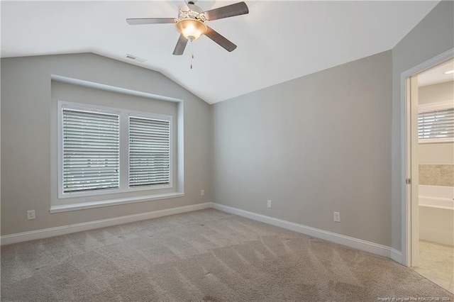 carpeted spare room featuring ceiling fan and lofted ceiling