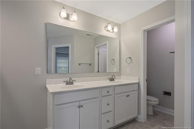 bathroom featuring tile patterned flooring, vanity, and toilet