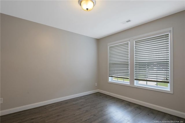 spare room featuring dark wood-type flooring