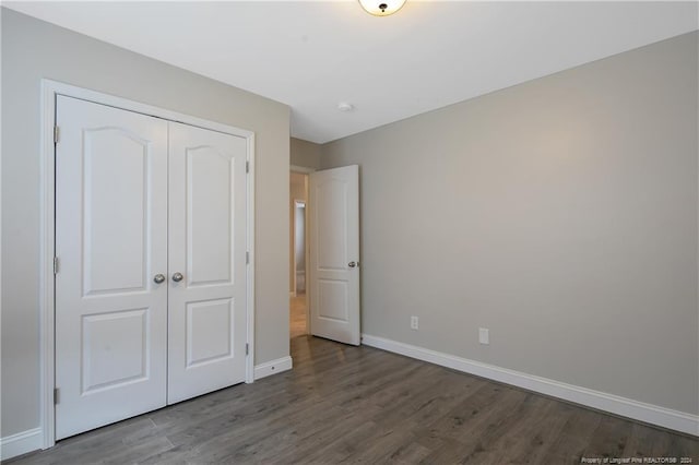 unfurnished bedroom with a closet and hardwood / wood-style flooring