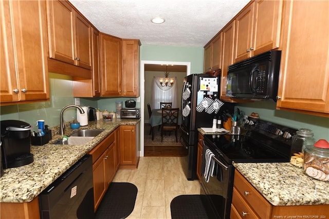 kitchen featuring sink, a textured ceiling, a chandelier, black appliances, and light stone countertops