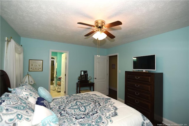 bedroom featuring ceiling fan, a textured ceiling, and connected bathroom