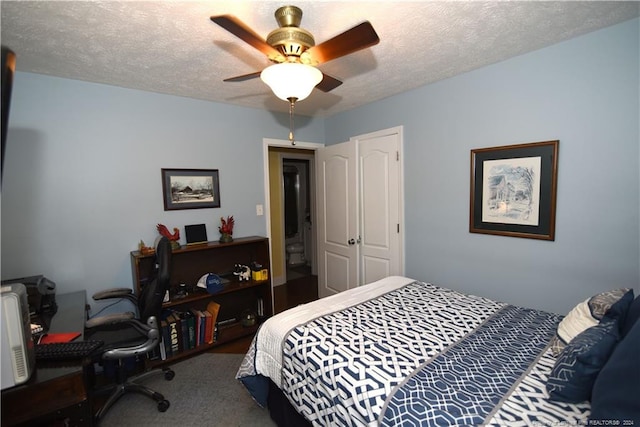 carpeted bedroom with ceiling fan and a textured ceiling