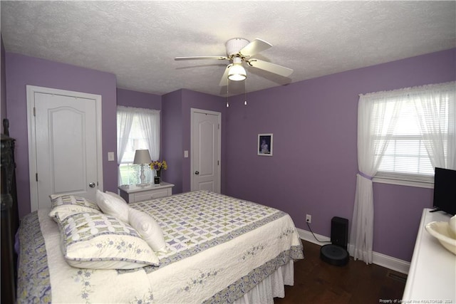 bedroom featuring dark hardwood / wood-style flooring, a textured ceiling, and ceiling fan