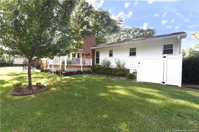 3760 Berkley Ln, Lumberton, NC 28358 - back of property featuring a yard, a wooden deck, and a chimney