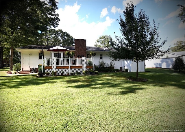 back of property featuring a wooden deck and a lawn