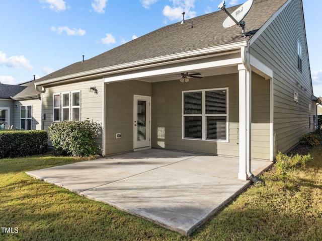 back of property with a patio, a yard, and ceiling fan