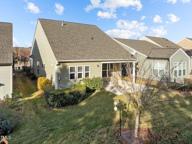 rear view of house with a patio and a yard