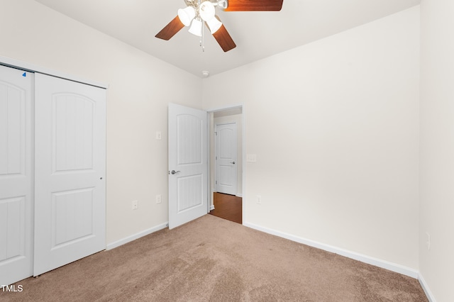 unfurnished bedroom with a closet, light colored carpet, and ceiling fan